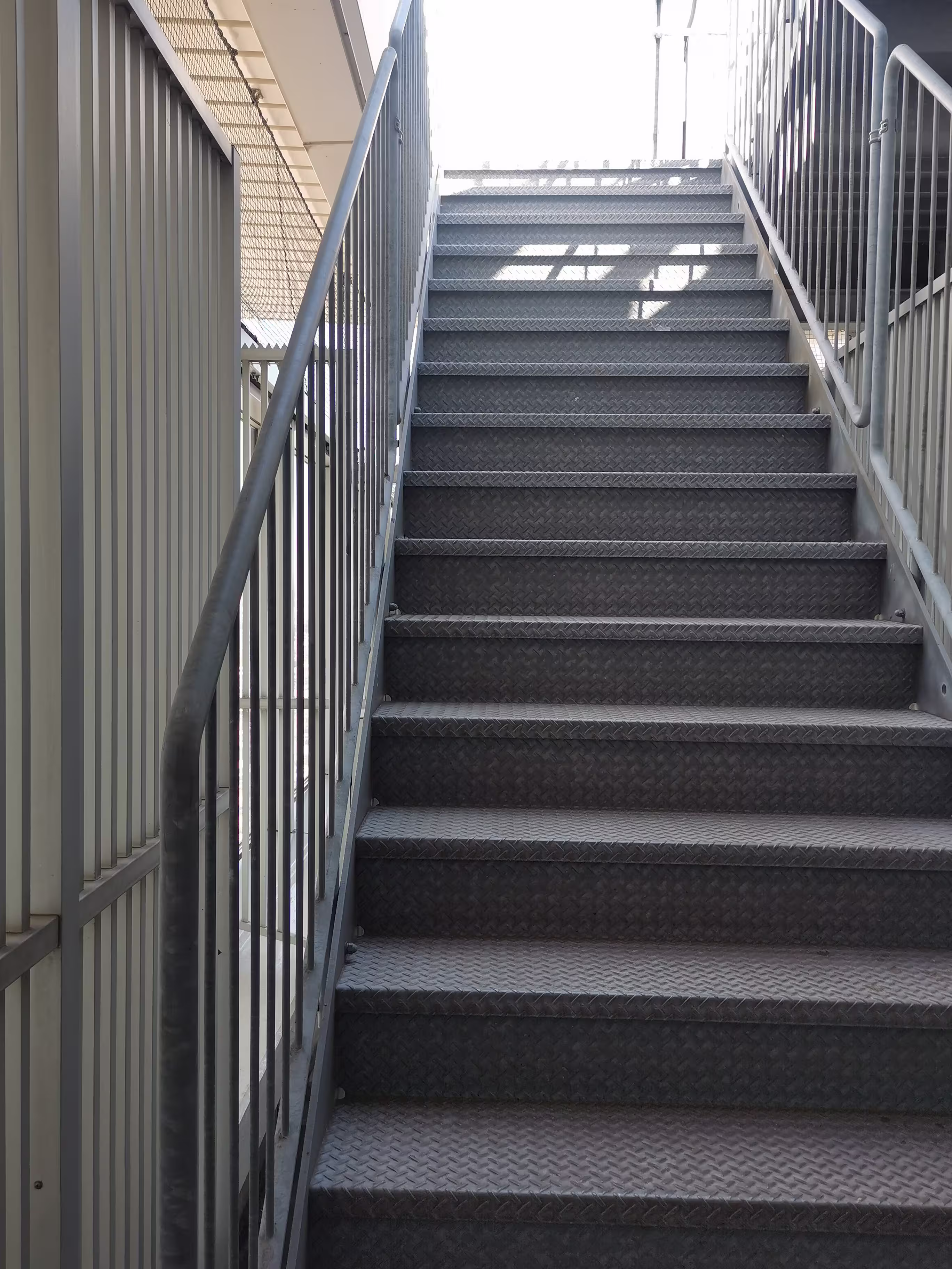 Vista lateral completa de escalera de servicio exterior para operador logístico