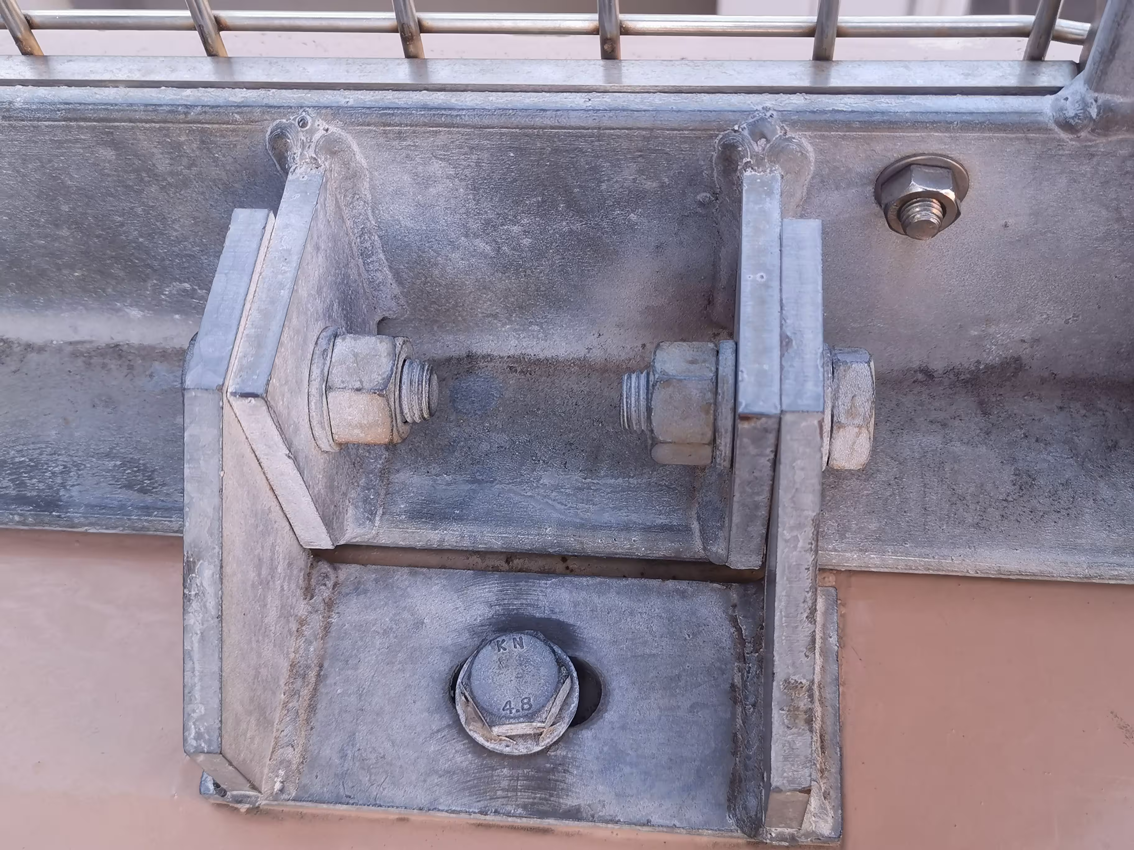 Detalle de tornillo galvanizado con arandelas planas y de presión en unión de rejilla